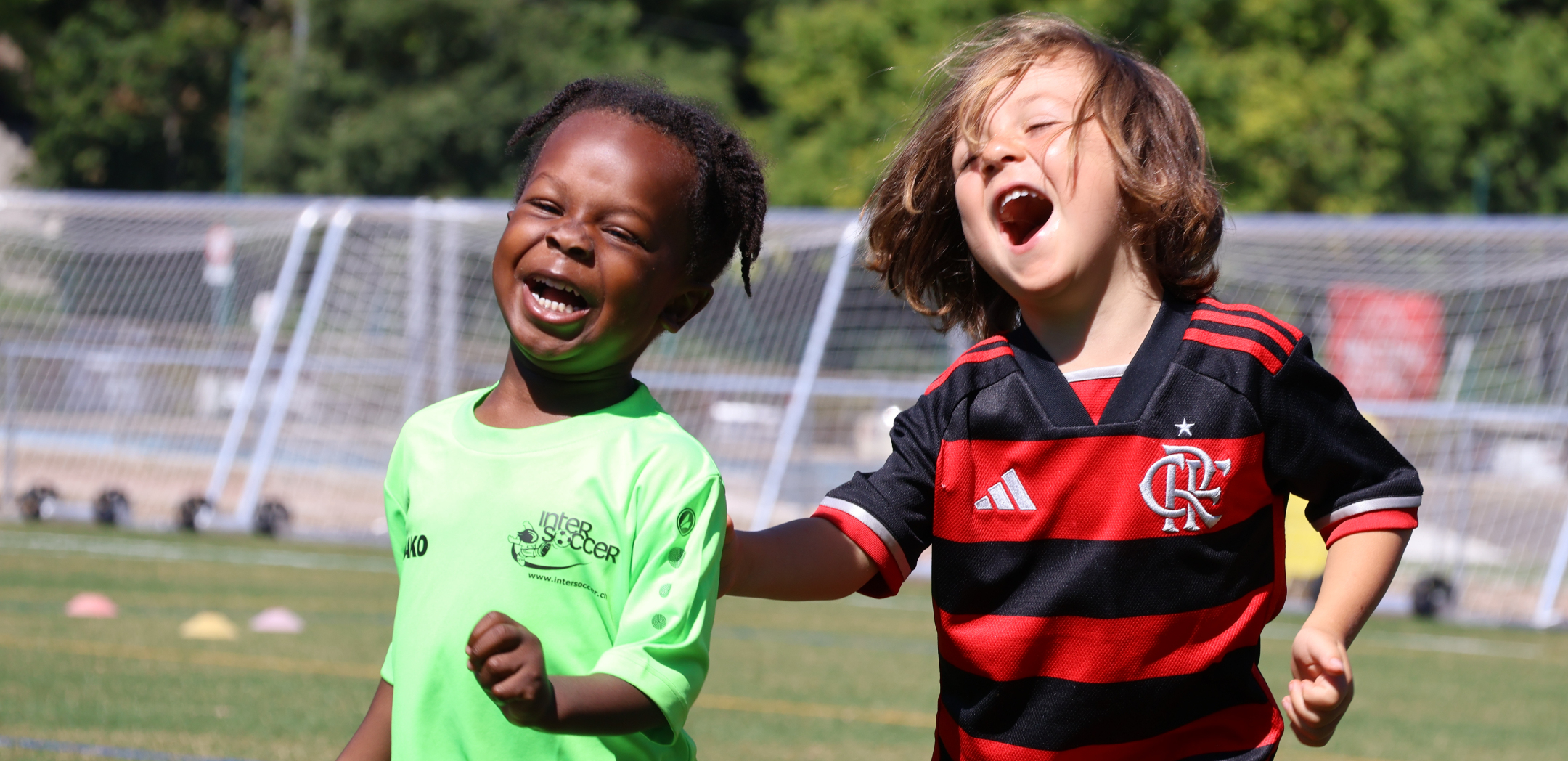 Deux enfants qui rient sur le terrain lors d'un camp InterSoccer